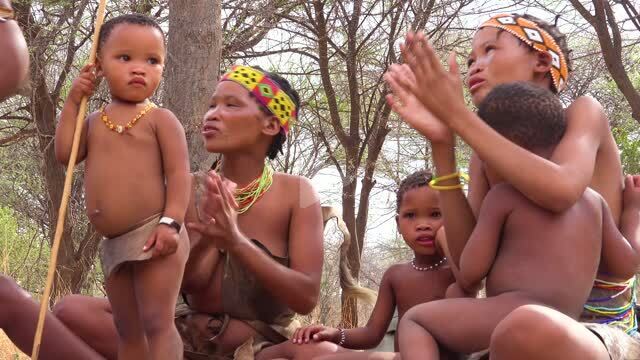 601 8661 african san bushmen women children and tribal natives sit in a circle chanting singing and clapping in a small village in